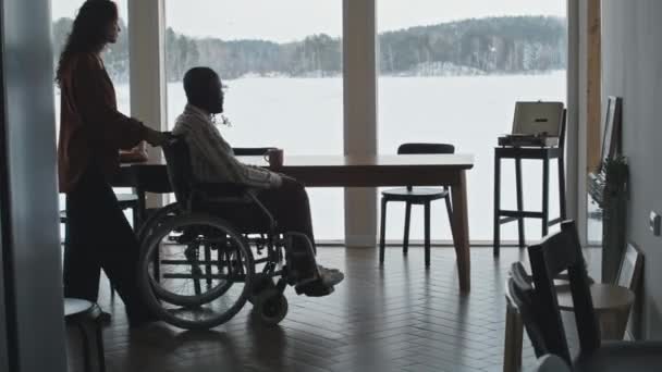 Καυκάσια Γυναίκα Οδηγεί Μαύρο Άνδρα Αναπηρική Καρέκλα Στο Σαλόνι Πανοραμική — Αρχείο Βίντεο