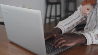Kafkasyalı kadının laptopunu kapatırken tekerlekli sandalyedeki zenciyi kucaklaması, ona gülümsemesi ve konuşması.