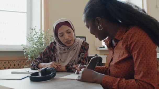 Glada Unga Svarta Och Mellanöstern Kvinnor Sitter Vid Bordet Klassrummet — Stockvideo