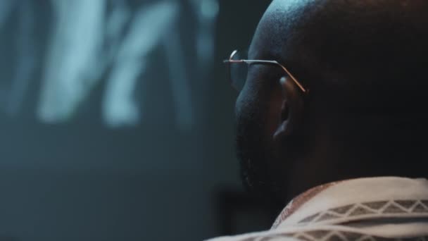 Närbild Afroamerikanska Glasögon Man Tittar Vänster Och Ler Medan Tittar — Stockvideo