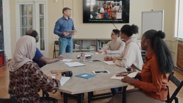 Grupo Estudiantes Migrantes Étnicamente Diversos Sentados Mesa Aula Levantando Las — Vídeo de stock
