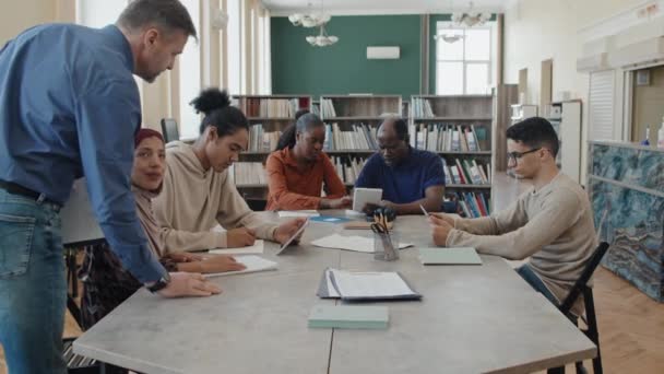 Reife Kaukasische Englischlehrerin Arbeitet Mit Einer Gruppe Ethnisch Unterschiedlicher Migranten — Stockvideo