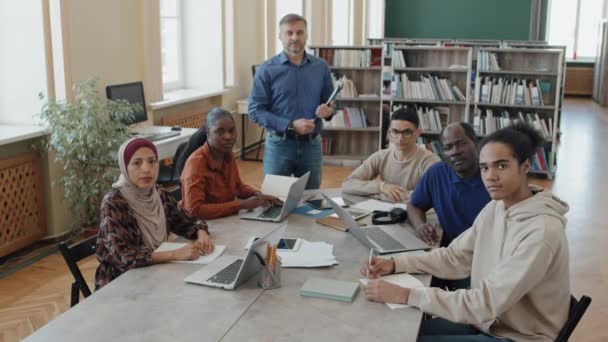 Portret Van Engelse Taaldocent Etnisch Diverse Groep Migrantenstudenten Die Bibliotheek — Stockvideo