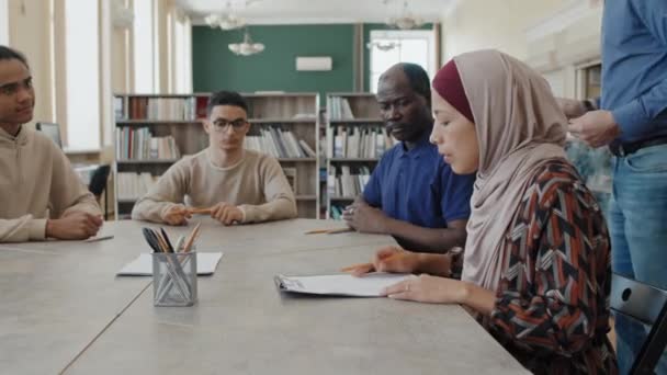 Ομάδα Πολυεθνικών Μεταναστών Φοιτητών Που Κάθονται Στο Τραπέζι Και Λαμβάνουν — Αρχείο Βίντεο