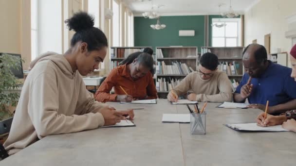 Multietnisk Grupp Invandrarstudenter Som Sitter Vid Bordet Biblioteket Och Arbetar — Stockvideo
