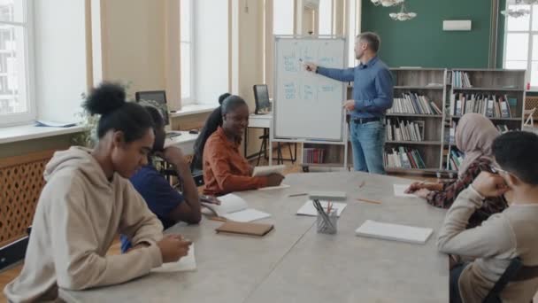 Ältere Kaukasische Englischlehrerin Arbeitet Mit Einer Gruppe Von Immigranten Und — Stockvideo