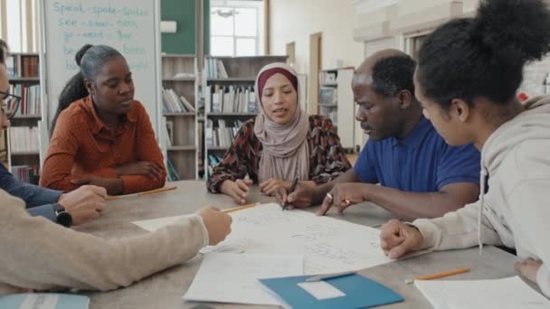 Grupo Estudantes Migrantes Multi Étnicos Sentados Mesa Biblioteca Fazendo Cartaz — Vídeo de Stock