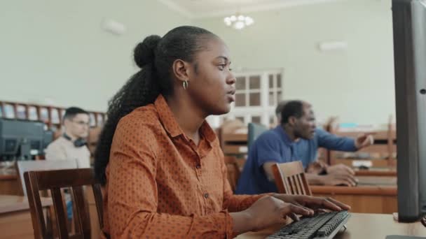 デスクトップコンピュータを使用してレッスンタスクに取り組む若い黒人移民女性の選択的な焦点ショット — ストック動画