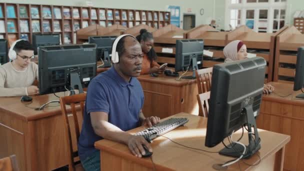 Groep Etnisch Diverse Migrantenstudenten Met Koptelefoon Koptelefoon Computers Bibliotheek — Stockvideo