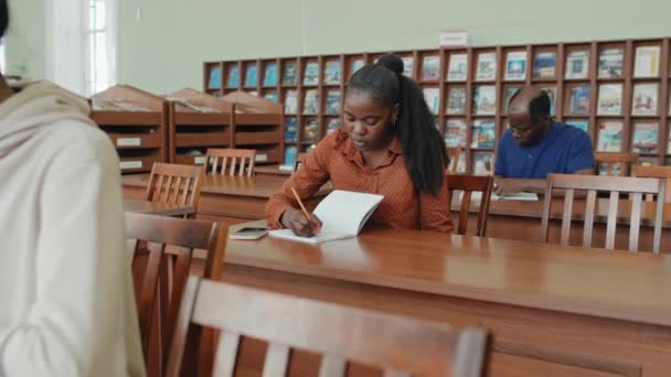 高级和年轻的黑人移民学生在语言课上坐在写字台前完成写作任务 — 图库视频影像