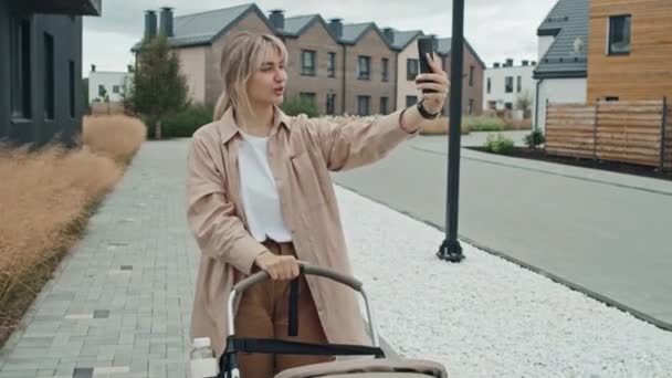 跟踪现代年轻母亲带着孩子在户外散步时 在智能手机上为博客录制视频的照片 — 图库视频影像