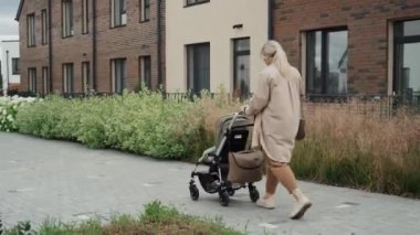 Küçük bir ihtimal, genç anne bebek arabasıyla sokakta yürürken görülüyor.