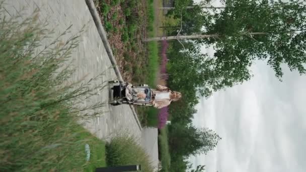 ベビーカーで赤ちゃんと一緒に歩いている間 スマートフォンで音声メッセージを録音する若い母親の垂直な長いショット — ストック動画