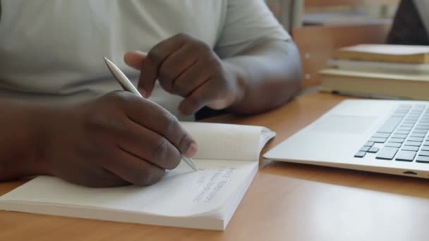 Tanımlanamayan Siyahi Erkek Üniversite Öğrencisi Masada Oturmuş Defterine Alıyor Dizüstü — Stok video