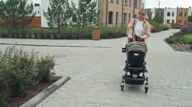 Bebek arabasını iterken, beyaz bir kadının bebeğiyle konuştuğu görüntüler.