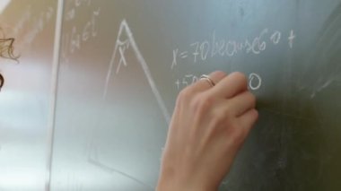 Tahtadaki geometri problemini çözen tanınmayan öğretmen veya öğrencinin yakın plan görüntüsü