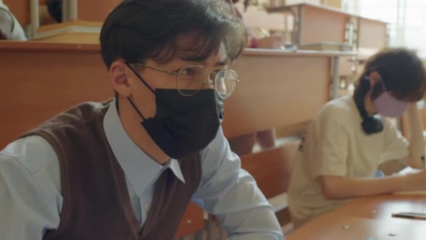 Jovem Estudante Asiático Vestindo Máscara Protetora Sentado Mesa Sala Aula — Vídeo de Stock