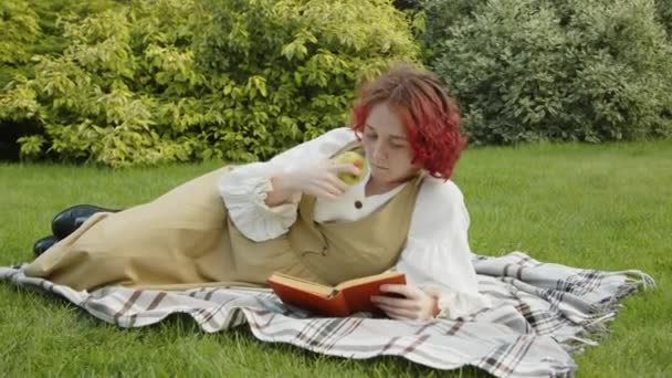 Дівчина Ген Старовинному Вбранні Відпочиває Газоні Задньому Дворі Їсть Яблуко — стокове відео