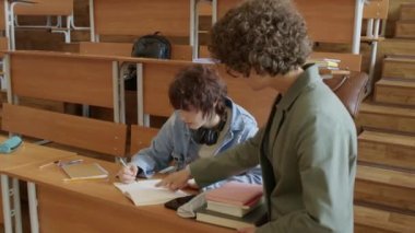 Matematik öğretmeni, kız üniversite öğrencisinin problemi çözerken hata bulmasına ve düzeltmesine yardım ediyor.
