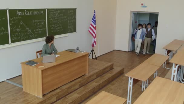 講堂に入る民族的に多様な大学生のロングショットと教師の挨拶 — ストック動画