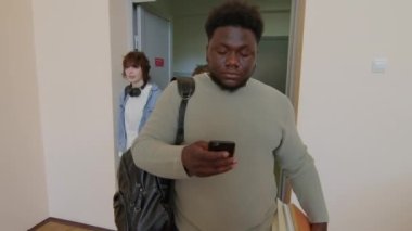 Etnik çeşitliliğe sahip bir grup genç üniversite öğrencisi konferans salonuna giriyor ve yerlerini alıyorlar.