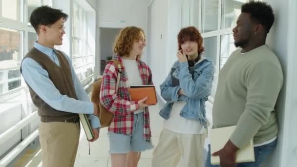 Többnemzetiségű Főiskolai Barátok Csoportja Áll Folyosón Hétvégi Vagy Nyaralási Tervekről — Stock videók