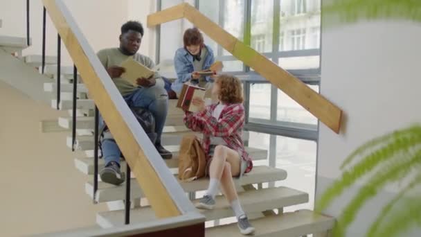 Група Студентів Сучасного Гену Коледжу Сидять Розслаблено Сходах Обговорюють Домашнє — стокове відео