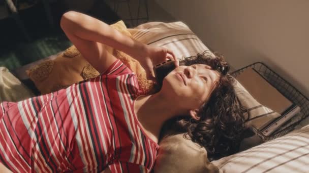 Yüksek Açılı Genç Kıvırcık Tişörtlü Kız Telefonla Konuşuyor Dağınık Yatakta — Stok video