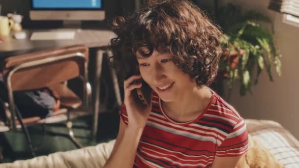 Genç Kıvırcık Saçlı Telefonla Konuşan Gülümseyen Arkasını Dönüp Pencereye Bakan — Stok video