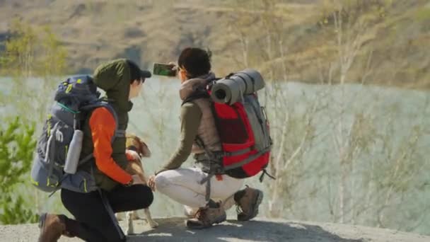 Koca Sırt Çantalı Iki Genç Turistin Kayalık Yamacın Kenarında Otururken — Stok video