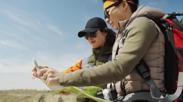Enge Mittlere Einstellung Zwei Asiatische Touristinnen Sonnenbrille Die Landkarte Studierend — Stockvideo