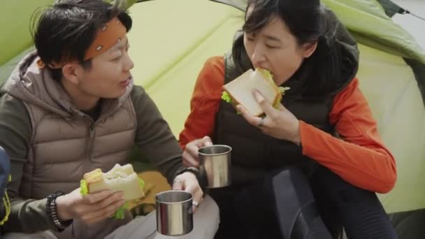 Tiro Médio Apertado Duas Amigas Asiáticas Sentadas Entrada Tenda Comendo — Vídeo de Stock