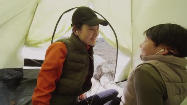 Asyalı Kadın Turistin Kayalık Göl Kıyısında Çadırda Oturup Müzik Dinlerken — Stok video