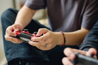 Kameranın önünde oturup boş vakitlerinde bilgisayar oyunu oynarken kontrol düğmelerine basan modern genç kızın ellerine odaklan.