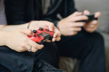 Bilgisayar başında boş zamanlarında erkek arkadaşının yanında otururken, oyun sırasında konsolda düğmelere basan kız çocukların elleri.