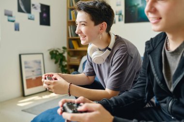 joystickli genç ve neşeli bir kadın boş zamanlarında erkek arkadaşının yanında oturup konsol tuşlarına basarken bilgisayar oyunu oynuyor.