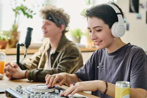 ハッピー 代の少女 ヘッドフォン 放送中にターンテーブルで音楽を作る マイクで話している彼女のボーイフレンドの隣に座っている間 — ストック写真