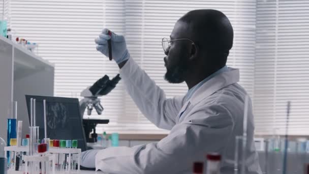 Побочный Обзор Афроамериканского Ученого Концентрирующегося Своей Работе Рабочем Месте Рассматривает — стоковое видео