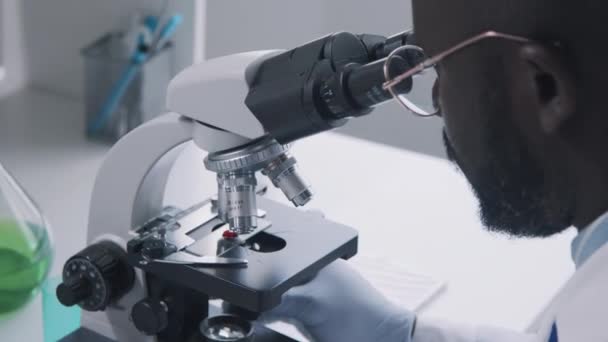 Gros Plan Scientifique Afro Américain Lunettes Regardant Travers Microscope Table — Video