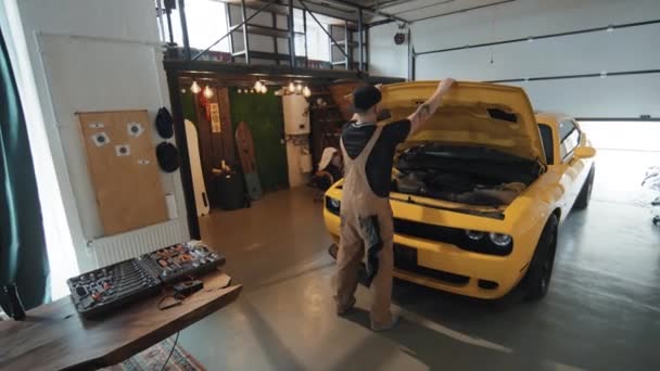 黄色汽车机械闭合罩检查或修理后的全高角后向拍摄 保持清洗布及离开车库 — 图库视频影像