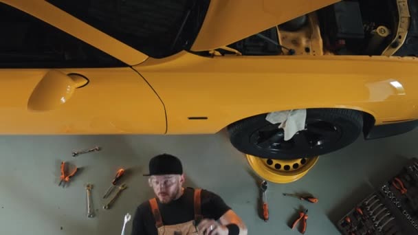 Araba Tamircisinin Tulumu Kep Google Sarı Araba Gövdesinin Altına Girerken — Stok video