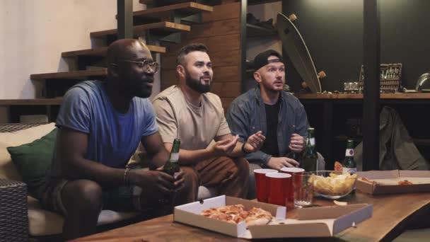 Oturma Odasındaki Kanepede Spor Izleyen Çok Irklı Arkadaş Ellerinde Bira — Stok video