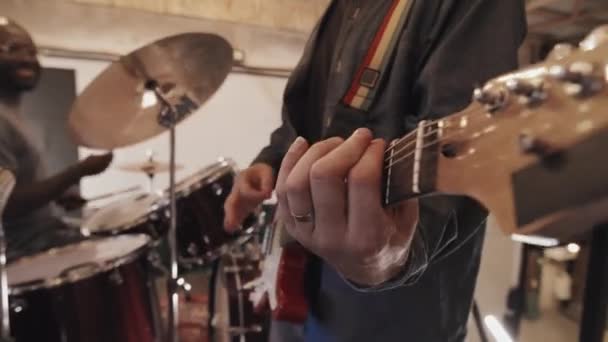 Środkowa Część Kręciła Białego Mężczyznę Grającego Gitarze Pierwszym Planie Planszy — Wideo stockowe
