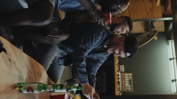 三个多种族的男性朋友在客厅里一起玩 做鬼脸 微笑着为自己辩护 喝啤酒 — 图库视频影像