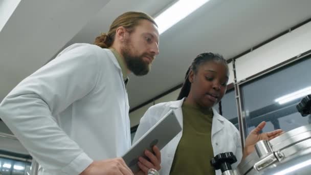 백인과 아프리카계 미국인 양조장 기술자의 양조장의 코트에서 유리를 과정을보고 — 비디오