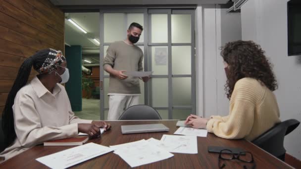 캐주얼 베이지 점퍼와 페이스 마스크에서 남자의 사무실에서 회의실 주위를 데이터와 — 비디오