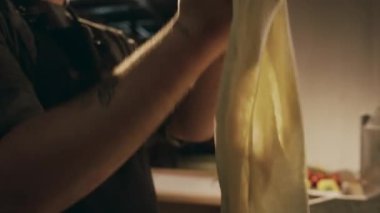 Lokanta mutfağında çalışırken pizza hamurunu dikkatlice şekillendiren ve esneten yetenekli beyaz erkek şefin orta boy yakın çekimi.