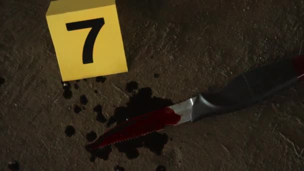 Zbliżenie Ręcznego Strzału Nożem Plamami Krwi Ziemi Żółtym Markerem Śledczym — Wideo stockowe