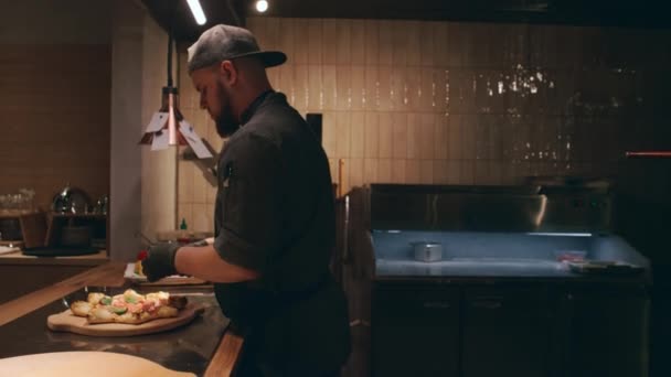 Chef Masculino Caucásico Joven Decorando Pizza Recién Horneada Con Hojas — Vídeos de Stock