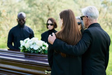 Back view of mature man in black suit embracing his grieving daughter at funeral and farewell ceremony of their relative, friend or family member clipart